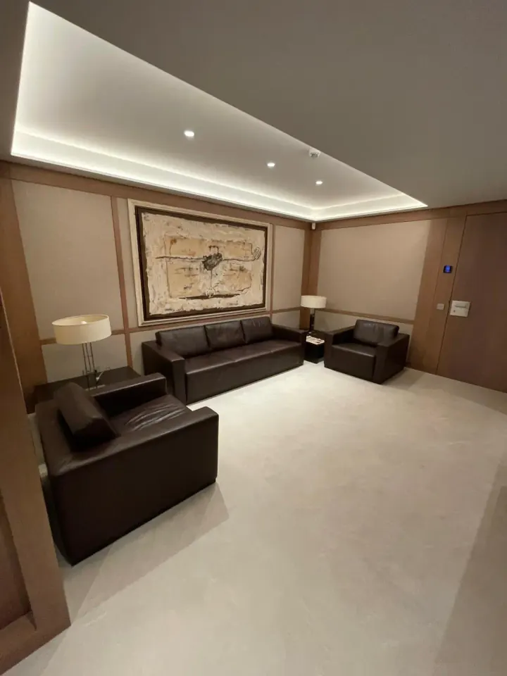Sala con paneles de madera y techo con luz indirecta